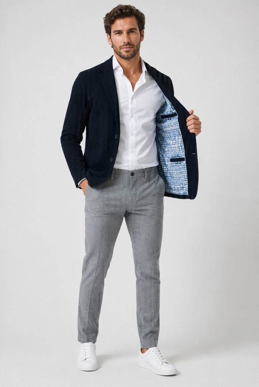 Men's Navy Knit Blazer - Patterned Lining — on model showing light knit texture and patterned lining, with contrasting grey trousers, white shirt and white sneakers